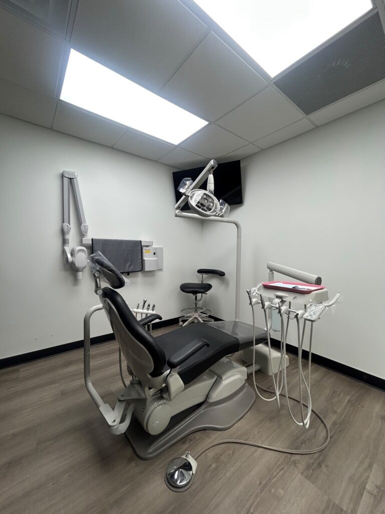 Dental operatory with chair and wall-mounted X-ray at Motor City Dental Group in Southwest Detroit